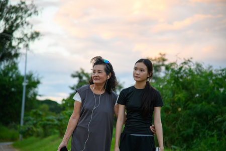 Grandmother and granddaughter enjoy a walk together in the park.の写真素材