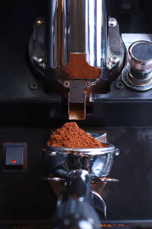 Close-up, coffee holder, ground coffee beans are poured into the filter and funnel background is blurredの写真素材