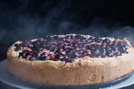 Berry pie cake from the cherries currants in a bowl of fresh steam a whole and slices of hot background blurredの写真素材
