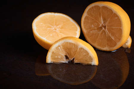 Slices of lemon citrus on the table juicy cut off reflection in the water juice blurred backgroundの写真素材