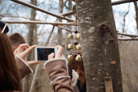 a tourist takes pictures of bells on a tree, a trip to the forest, traditional jewelry, decorative...