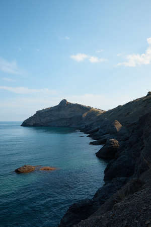 rocky shore in the sea, wild beach and mountains, the rock goes into the water, sea view, wild...