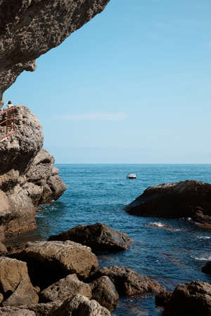 Sea view from a rocky cave, boat in the sea, rocks and rocks, seascapeの写真素材