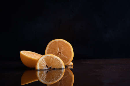 Slices of lemon citrus on the table juicy cut off reflection in the water juice blurred backgroundの写真素材