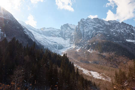 Landscape in the mountains, river and coniferous forest, autumn, the first snow on the slopes, fallen trees and shrubsの写真素材