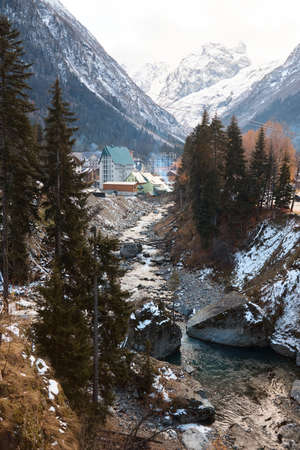 Landscape in the mountains, river and coniferous forest, autumn, the first snow on the slopes, fallen trees and shrubsの写真素材