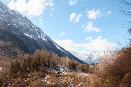 Landscape in the mountains, river and coniferous forest, autumn, the first snow on the slopes, fallen trees and shrubsの写真素材
