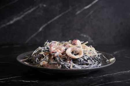 black pasta with shrimp and seafood, spaghetti, noodles, plate on a dark background, Asian cuisineの写真素材