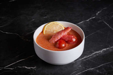 asian soup with meat and seafood, plate close-up on a dark background, vegetablesの写真素材