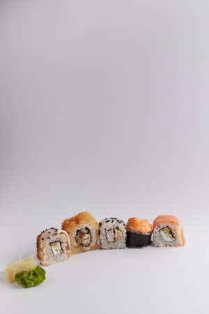 several different rolls on the table, Asian food, side view, light background, sushi, ginger and wasabiの写真素材