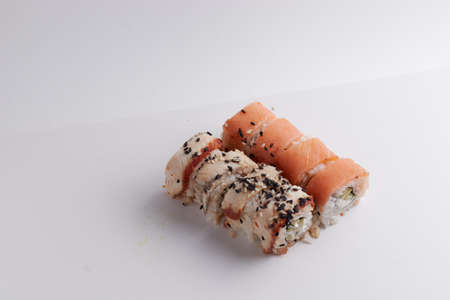 a portion of rolls on a stand, japanese food, sushi on the table, chinese chopsticks, light backgroundの写真素材
