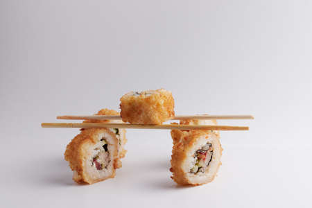 several rolls on the table, asian food, balance on chinese chopsticks, side view, sushiの写真素材