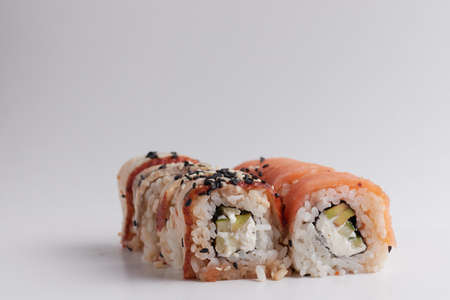 a portion of rolls on a stand, japanese food, sushi on the table, chinese chopsticks, light backgroundの写真素材