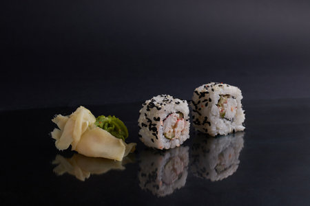 several different rolls on the table, asian food, side view, dark background, sushi, ginger and wasabiの写真素材