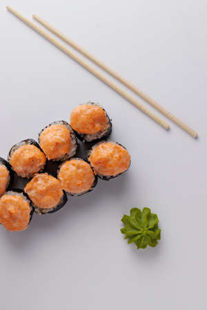a portion of rolls on a stand, japanese food, sushi on the table, chinese chopsticks, light backgroundの写真素材