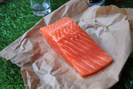 Red fish on the table, a slice of fish, seafood and alcohol, green lawn, salted fishの写真素材