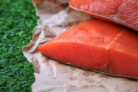 Red fish on the table, a slice of fish, seafood and alcohol, green lawn, salted fishの写真素材