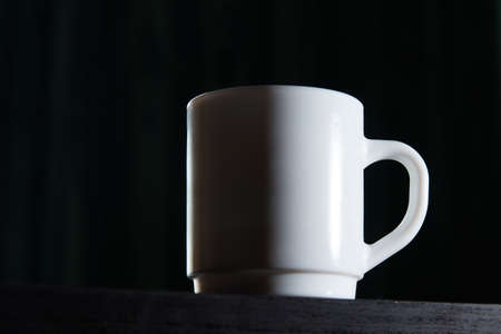 White mug for tea and coffee in on a dark background, close-upの写真素材