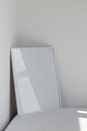 Large white photo frame on the floor, mockup, poster on the wall, light backgroundの写真素材