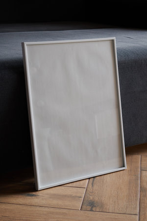 Large white photo frame on the floor, mockup, poster against the wall, dark backgroundの写真素材