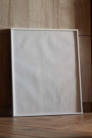 Large white photo frame on the floor, mockup, poster against the wall, dark backgroundの写真素材
