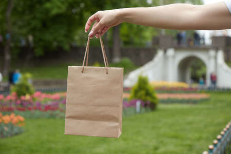 Mockup, paper bag with handles, girl holding in hand, close-up, your designの写真素材