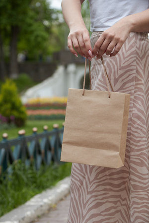 Mockup, paper bag with handles, girl holding in hand, close-up, your designの写真素材