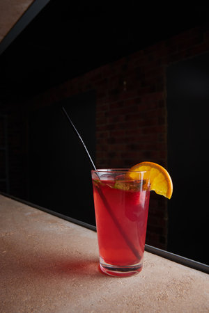 fruit berry lemonade in glass on table, lemon slice, straw, fruit drink, dark backgroundの写真素材
