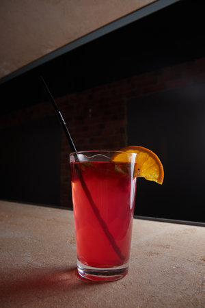 fruit berry lemonade in glass on table, lemon slice, straw, fruit drink, dark backgroundの写真素材