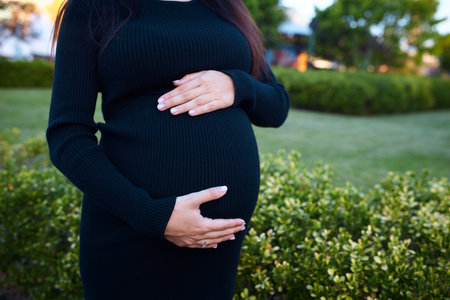 pregnant girl holding her belly, around flowers and plants, in gardenの写真素材