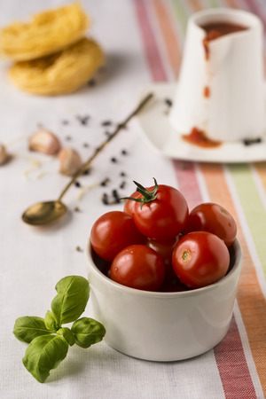 Red cherry tomatoes in a white ceramic plate on linen napkin.Background.Selective focus.の写真素材