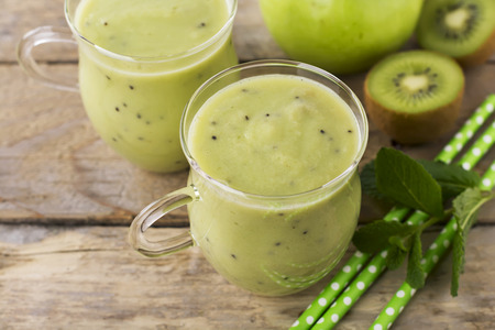 Fresh homemade kiwi juice in a glass jar on white background.の写真素材