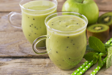 Fresh homemade kiwi juice in a glass jar on white background.の写真素材