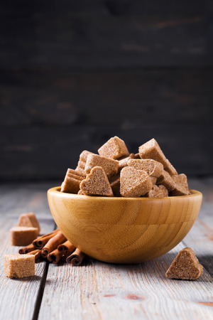 Sugar with cinnamon in the form of heart in a bamboo plate on a dark wooden background. Selective focus.の写真素材