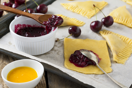 Raw ingredients for homemade cakes with cherry on a dark wooden background. Rustik style. Selective focus.の写真素材