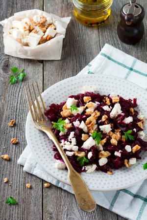 Salad of beetroot, feta and walnuts with leaves of parsley on the old wooden background. Selective focus.の写真素材