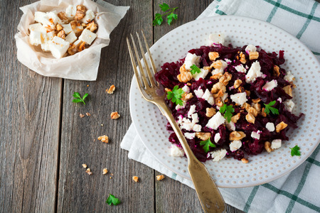 Salad of beetroot, feta and walnuts with leaves of parsley on the old wooden background. Selective focus.の写真素材