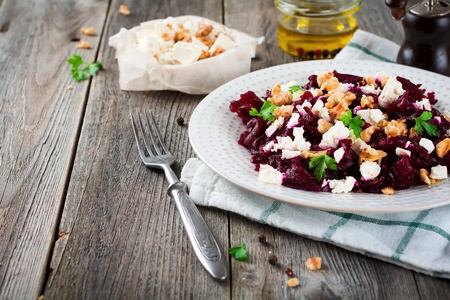 Salad of beetroot, feta and walnuts with leaves of parsley on the old wooden background. Selective focus.の写真素材