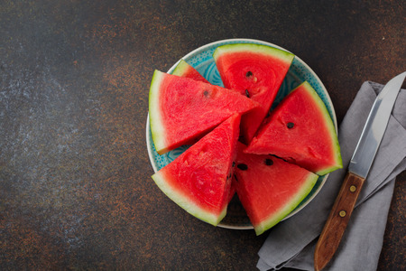 Fresh raw watermelon cut into pieces on  gray stone background. Selective focus. Top view. Copy space.の写真素材