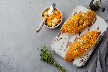 Bruschetta with baked pumpkin, feta cheese and thyme on  gray stone or concrete background. Spicy pumpkin sandwich. Selective focus. Top view.の写真素材