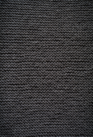 Black knitted wool texture background pattern vertical background. Selective focus. Top view. Copy space.の写真素材