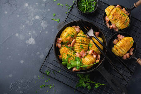 Baked potatoes with ham, herbs and breadcrumbs on dark background. Scandinavian cuisine. Top view.の写真素材