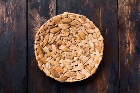 Brown rattan plate and wooden spoon on old wooden background. Table setting.の写真素材