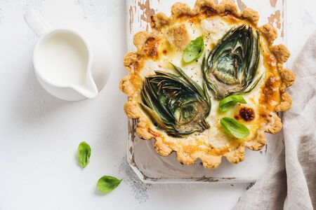 Homemade quiche tart with with artichoke on light wooden background. Vintage style. Top view.の写真素材
