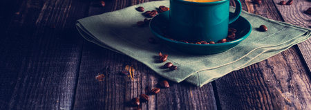 Cafe background with a green cup of espresso coffee standing on a linen napkin with a retro coffee grinder old book. Retro style Nashville. Tonted image. Banner.の写真素材