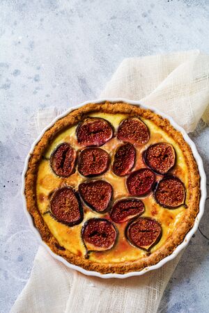 Homemade quiche tart with figs, cream cheese and honey on light wooden background. Vintage style. Top view.の写真素材