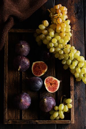 Fresh grapes and figs on an old wooden background in retro style.  Top view.の写真素材