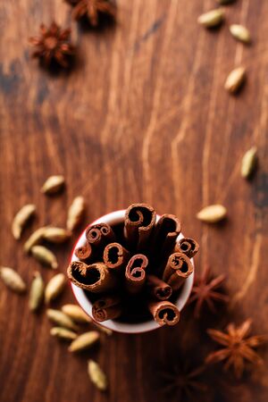 Cinnamon Sticks in a red ceramic cup on a rustic brown background. Top view.の写真素材