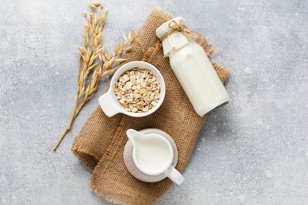 Homemade diet vegetable milk made from oatmeal on a gray background. Diet healthy concept. Copy space and Banner.Top view.の写真素材