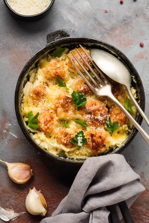 Meatballs with cheese and cream sauce in cast iron pan on gray vintage background. Top view.の写真素材